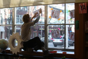 A window display designer setting up a window display at Providence Public Library