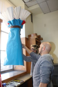 A window display designer setting up a display at Providence Public Library