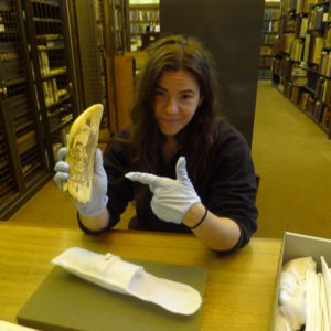 An archivist holding an example of scrimshaw, part of the Nicholson Whaling Collection at Providence Public Library