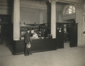 A patron receives help at the reference desk - black and white photo