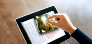 A stock image of a person reading a book on tablet computer