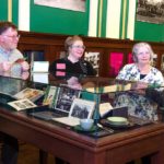 People looking in cases at the On The Table exhibition opening at Providence Public Library