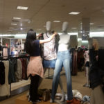 A Teen Squad member dresses a mannequin