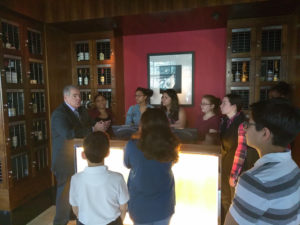Teens listening to a sommelier as part of a Teen Squad culinary arts program