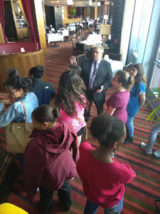 Teens listening to a sommelier as part of a Teen Squad culinary arts program