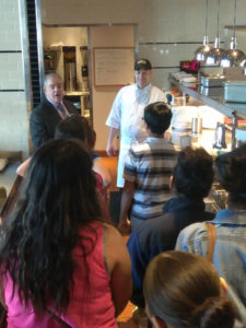 Teens talking to a chef as part of a Teen Squad culinary arts program