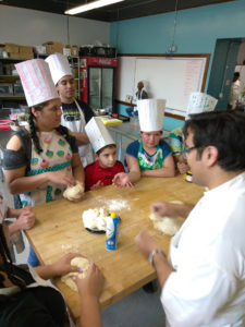 Teen Squad program participants knead dough in a kitchen