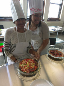 Two Teen Squad members posing with quiches they prepared as part of the culinary arts program