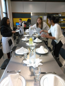 Teen Squad members prepare a dining table with place settings