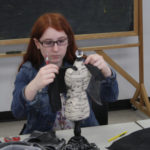 A Teen Squad member constructing a dress on a miniature dress form