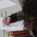 A Teen Squad member sketching a 1920s style dress using colored pencils