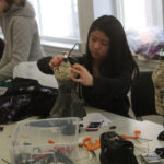 A Teen Squad member constructing a 1920s style dress on a miniature dress form