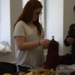 A Teen Squad member works on a miniature dress form.