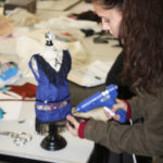 A Teen Squad member hot glues fringe onto a 1920s flapper style dress