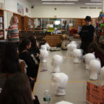 A mentor showing headdress to a group of Teen Squad participants