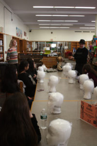 A mentor showing headdress to a group of Teen Squad participants