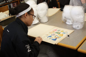 A Teen Squad member looks at historic dress illustrations