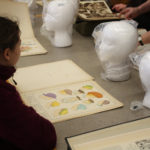 A Teen Squad member looks at historic headdress illustrations