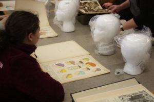 A Teen Squad member looks at historic headdress illustrations