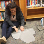 A Teen Squad participant uses an iron to prepare fabric