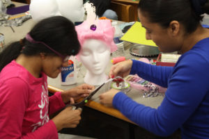 Teen Squad members cut material used to decorate a turban