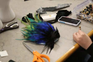 A headdress decorated with violet, green and yellow feathers