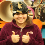 A Teen Squad member wearing a black turban with gold jewelry on it