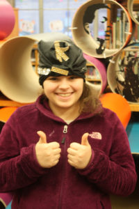 A Teen Squad member wearing a black turban with gold jewelry on it