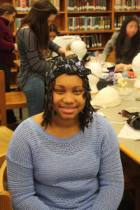 A Teen Squad member wearing a black headdress with violet trim