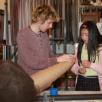 Teen Squad Visual Merchandising program participants preparing a window display