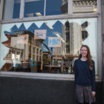 A Teen Squad member posing with a window display at Providence Public Library