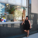 A Teen Squad member posing with a window display at Providence Public Library