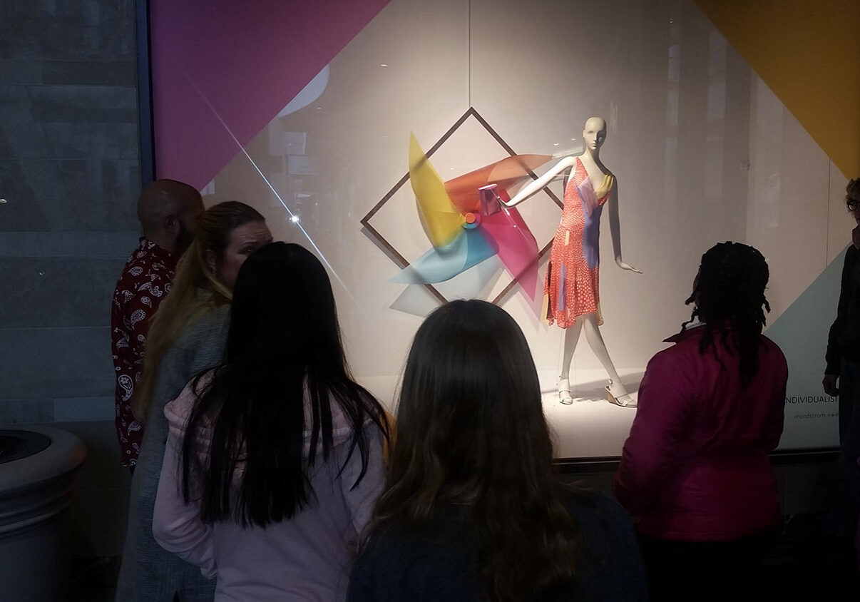 Teen Squad members look at a window display at Nordstrom